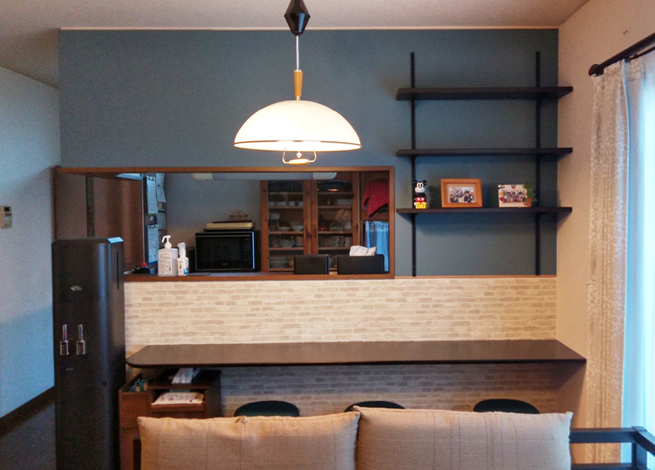 キッチン前にカウンターを取り付け、壁は濃いブルーとレンガ調のクロスに貼り分けました。<br />
カフェのようなLDK空間が完成しました。