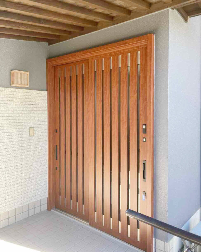 玄関扉はLIXILリシェントをセレクトしました。<br />
茶色の太い縦格子で和モダンな雰囲気へと変わりました。