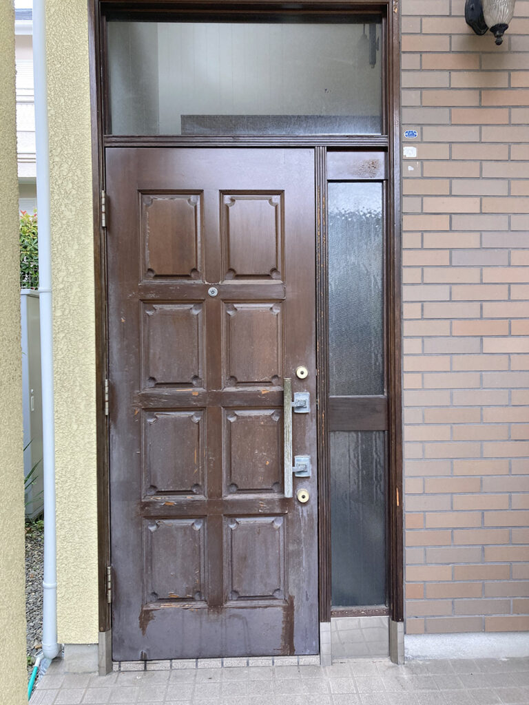 塗装前の玄関扉。<br />
経年劣化で汚れがきになっていました。<br />
愛着のある木製のドアは、交換ではなく塗装を選びました。