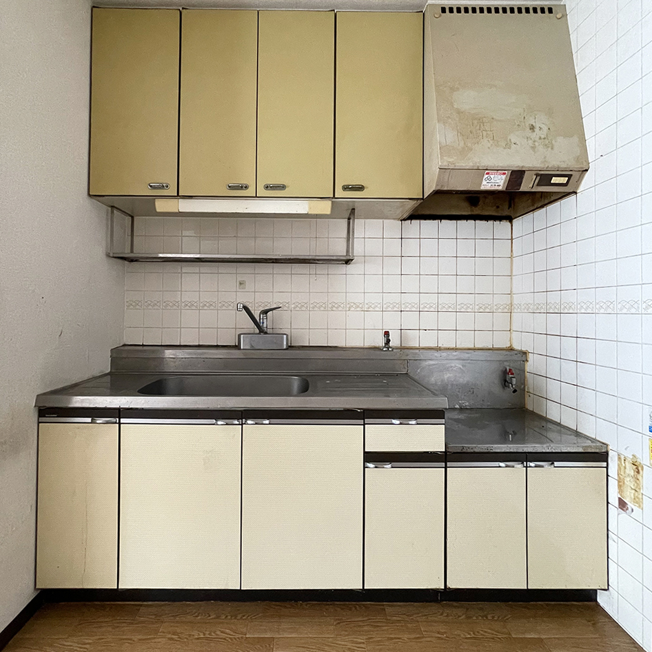 リノベーション前。<br />
壁付けのキッチンは、手前の壁で区切られ、狭く暗い印象でした。<br />
<br />
設備も古くなり汚れも目立ちます。