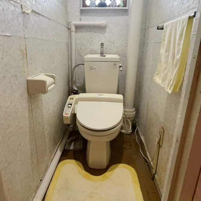 壁紙の剥がれや、トイレ本体の経年劣化も気になるリフォーム前のトイレ。<br />
