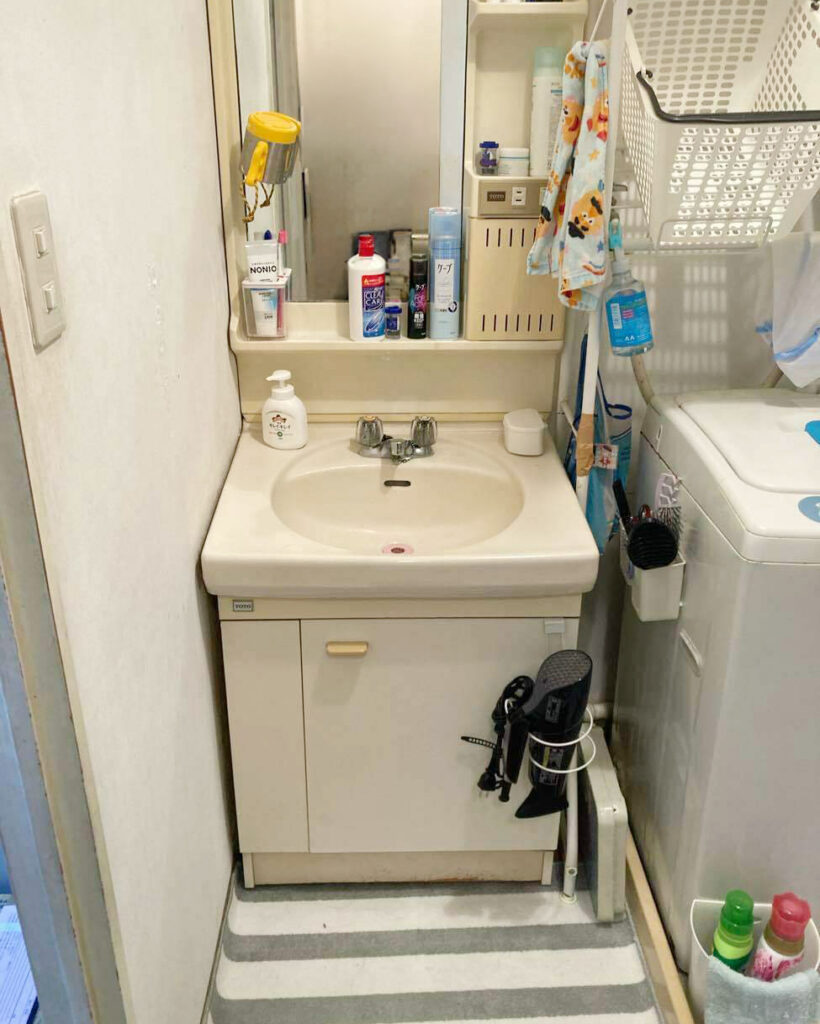 一面鏡まわりの小物があふれ、洗濯機とのすき間など限られた広さの中で動線が窮屈だった施工前の洗面所。