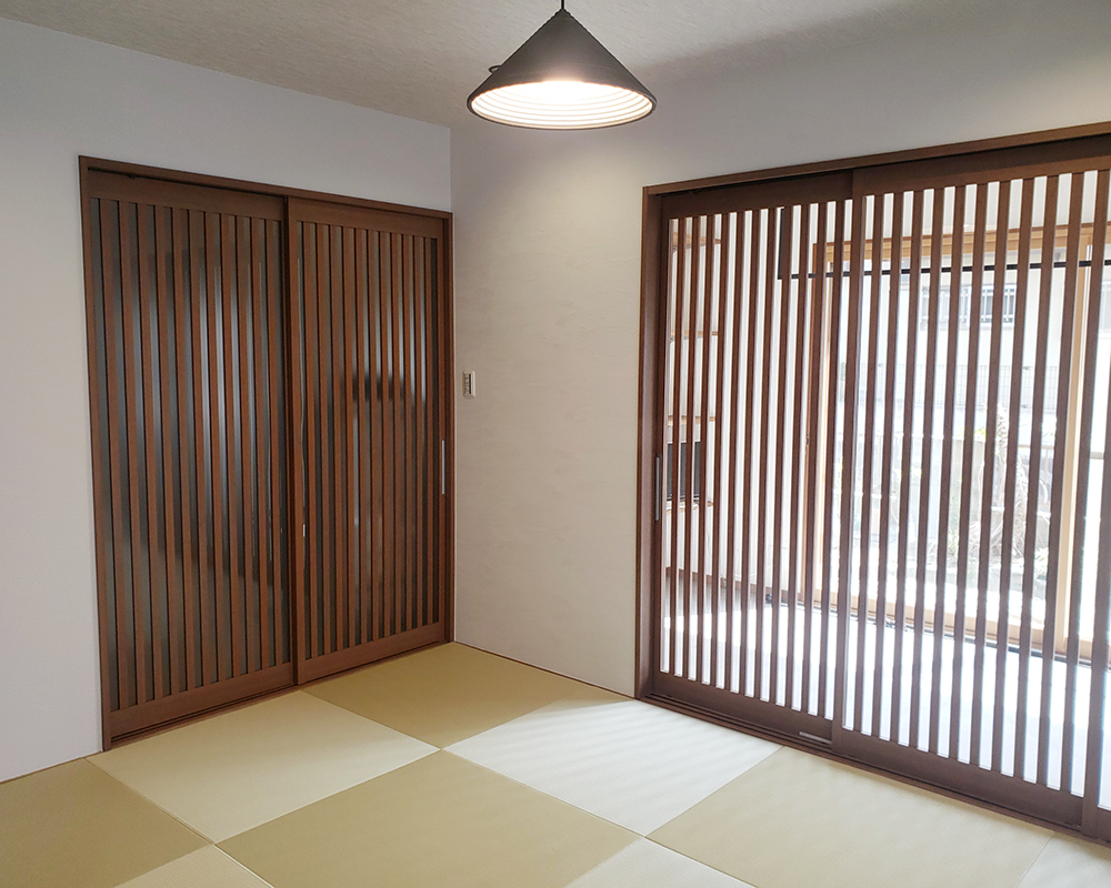 畳は琉球畳をセレクト。<br />
壁の色は白色になり、建具のダークブラウンの色が映えます。<br />
縦格子の扉から柔らかい光が差し込む、居心地の良い和室が完成しました。