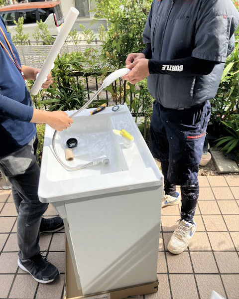 搬入した洗面台に、現場で水栓を取り付けます。