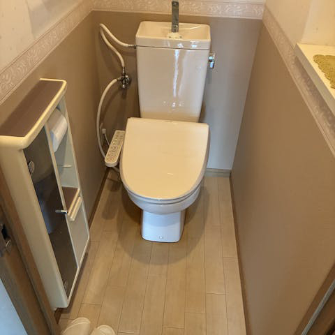 便座からの水漏れが発生していた施工前のトイレです。既存の便器と手洗いタンク、壁面の埋込収納を取り外し、全体をリニューアルしていきます。