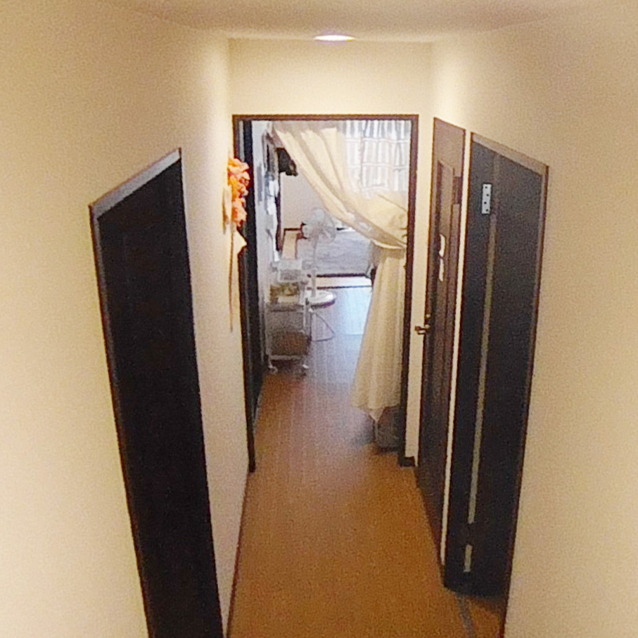 玄関からまっすぐ伸びる廊下。<br />
床や扉の色は赤味のあるブラウン。<br />
スッキリしない印象でした。<br />
