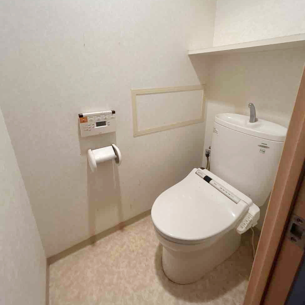 背面にタンクがある一般的な手洗い付きトイレ。
壁紙や床材もシンプルなものでした。