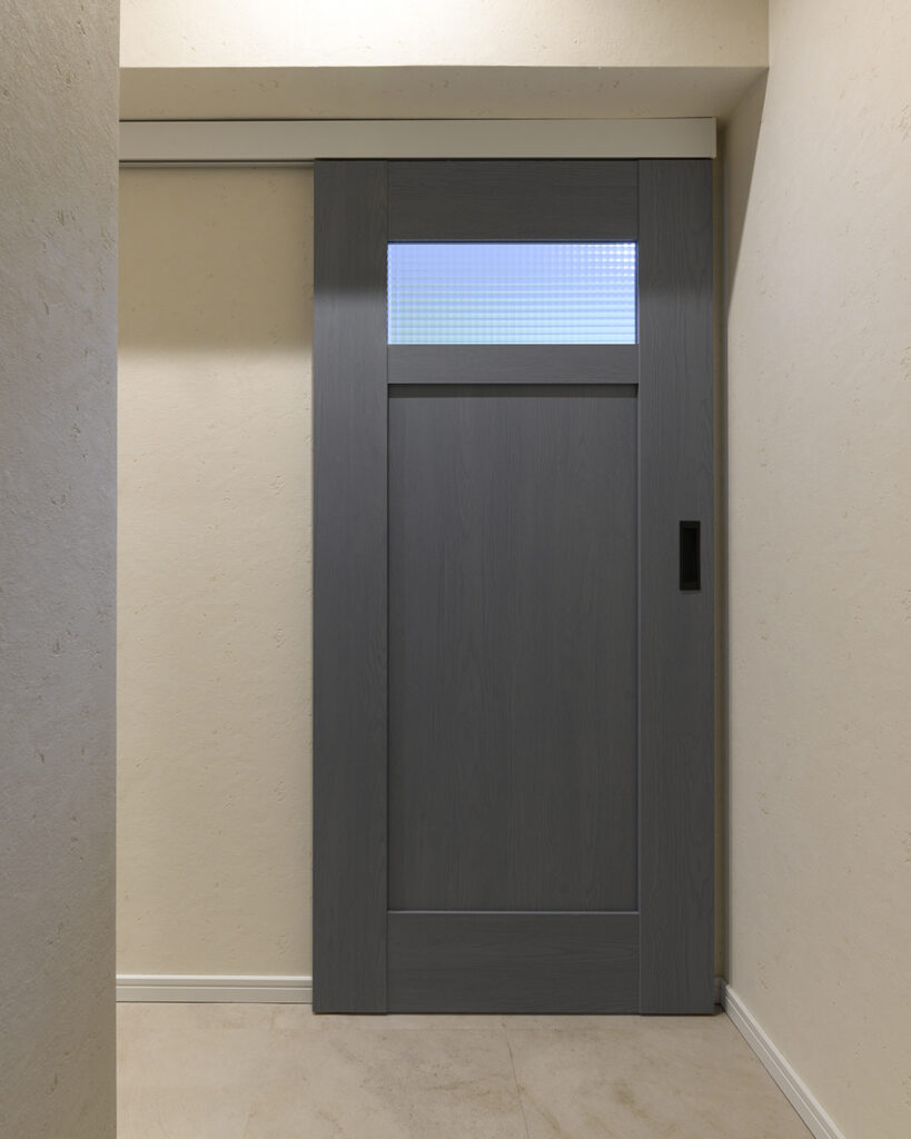 個室の扉はPanasonicクラフトレーベル。<br />
上部の梁に合わせて長さをカットしたオーダー仕様です。