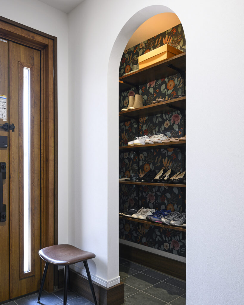玄関には靴をスッキリ収納できる大容量のシューズクロークを新設。<br />
背面にはアクセントクロスがちら見え。
