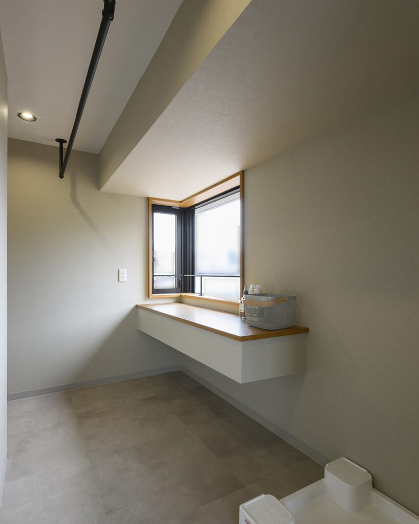 洗面所はランドリールームと直結。
<br>室内干し用のアイアンバーも、デザイン性を損なわず設置しています。