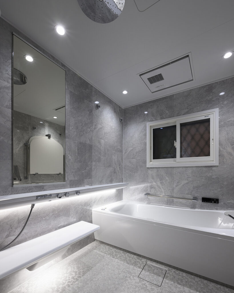 TOTO「シンラ（SYNLA）」を採用。
TOTOの最高級シリーズ「シンラ」を導入し、ホテルのようなラグジュアリーなバスルームへと一新しました。
浴室は肩湯ができる浴槽に取り替え、頭上にはレインシャワーを設置。
調光調色システムも採用し、ムードたっぷり。
日々の疲れを優しく包み込む、贅沢なシャワータイムを実現しています。