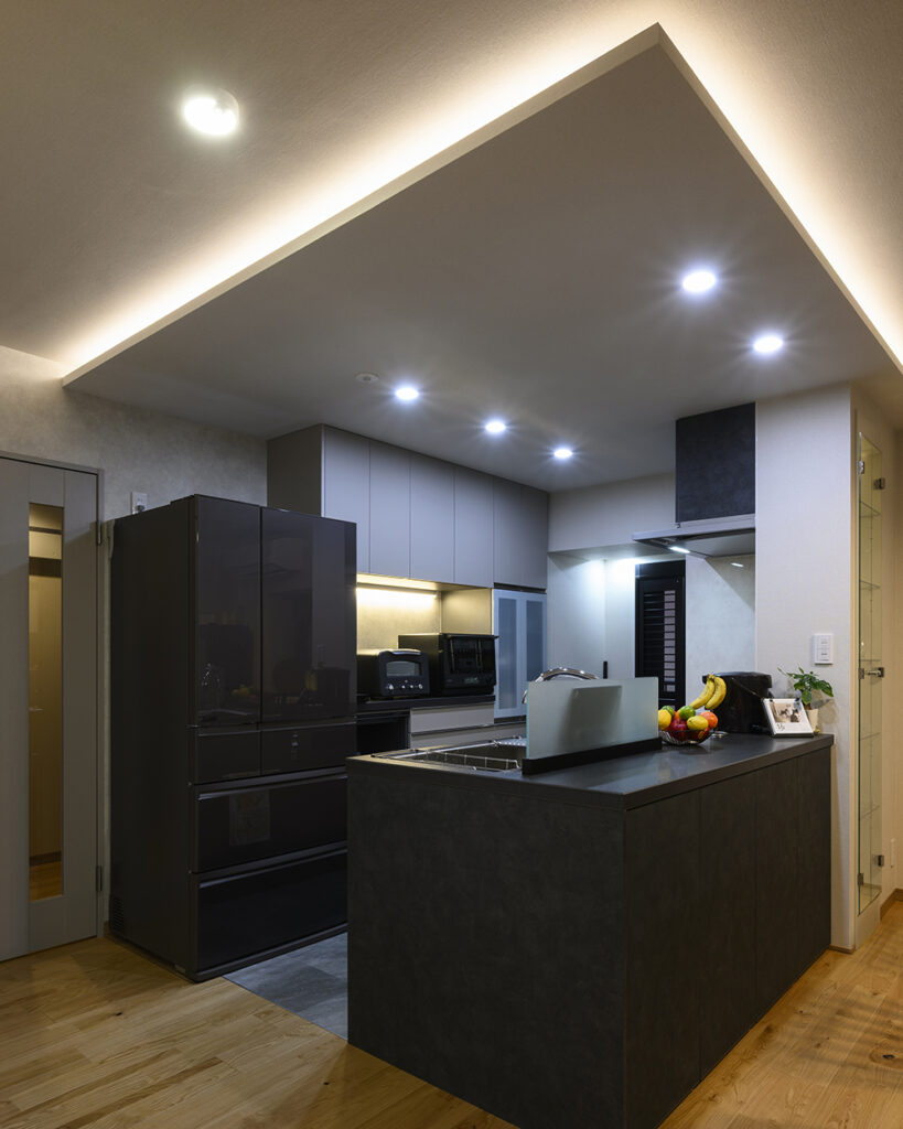 吊り戸をなくし、LIXILの「リシェル」を据えた開放的な対面キッチン。
ご主人がセレクトしたシックなブラックの対面キッチンにより、空間全体がラグジュアリーに引き締まりました。 
また、視覚的な広がりだけでなく、エアコンの風通しも良くなり、夏場も快適に調理ができる環境を整えました 。
床はフローリングからフロアタイルへと貼り替えました 。
水や油跳ねによる汚れも拭き取りやすく、機能性を高めています。