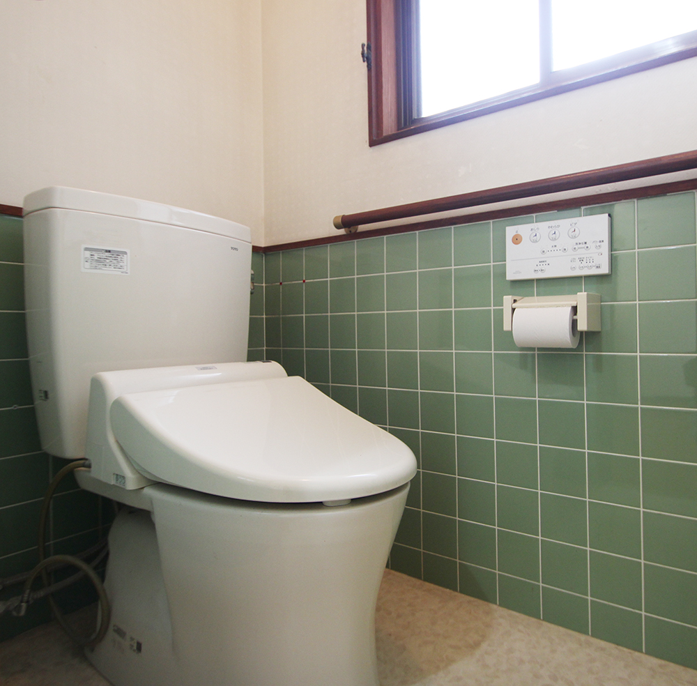 若草色のタイルにベージュの壁が、和風の印象のトイレです。