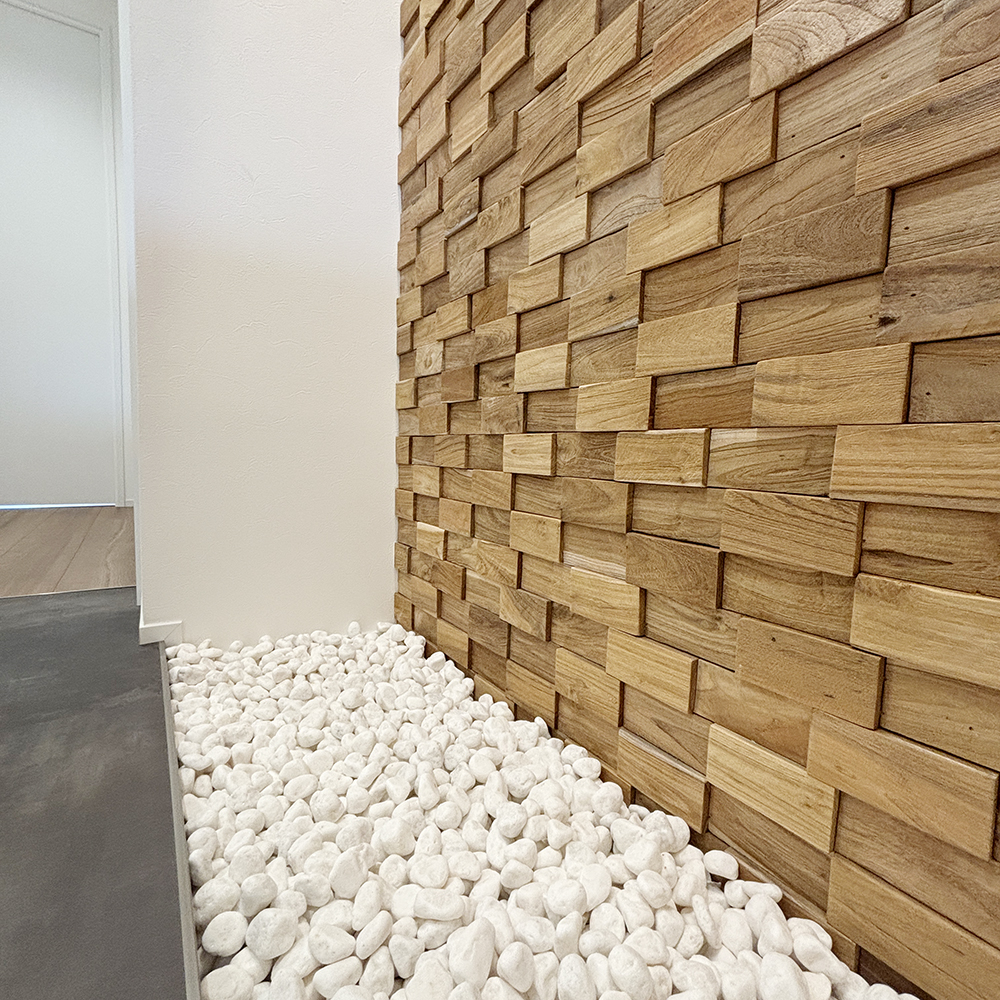 壁には、インドネシアの古材を再利用したミラタップ社のバンピーウッドを採用。<br>下に敷いた白い石材とともに、本物の素材ならではの高級感が漂います。