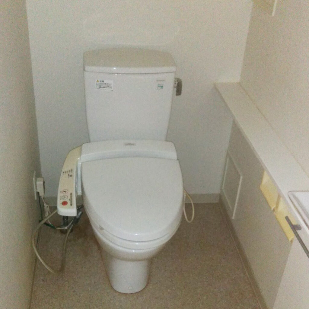 リフォーム前のトイレ。<br />
備え付けの手洗い付きカウンターはそのまま活かしてリフォームします。
