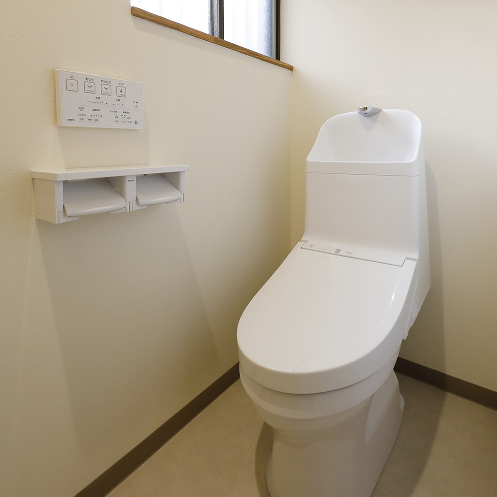 タイル張りのトイレは、ホワイトの壁紙とベージュのクッションフロアで優しい印象の内装になりました。
