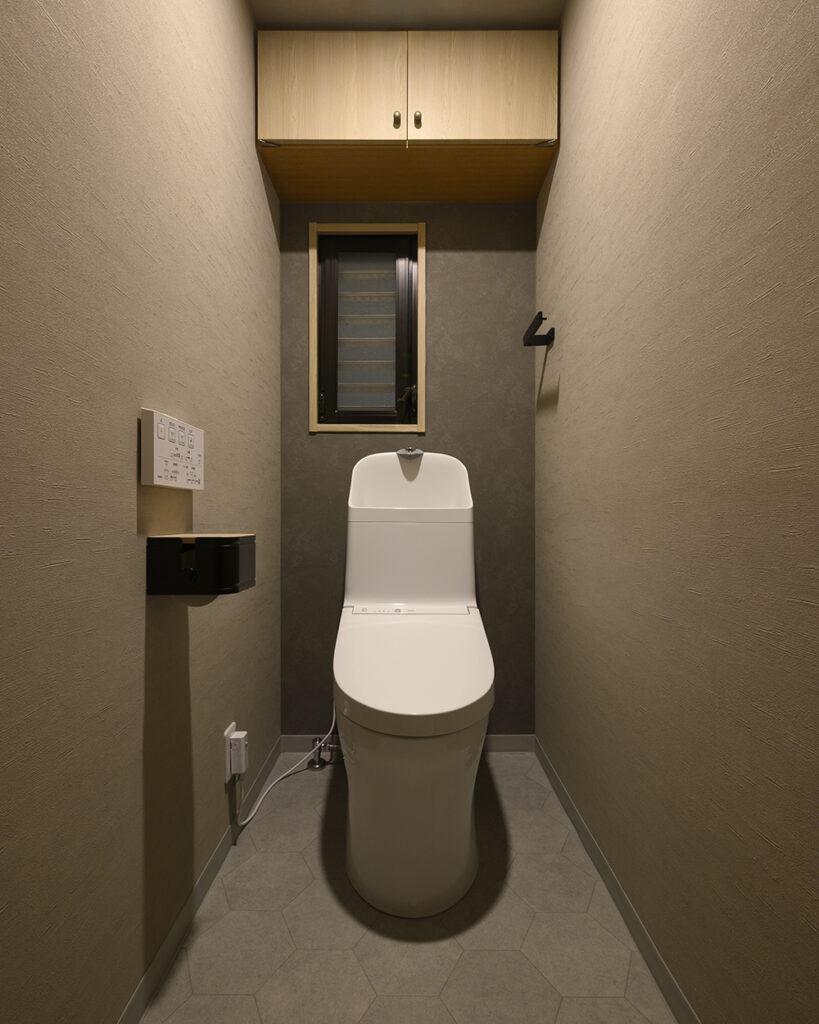 トイレはTOTO「ZJ1」を採用。
シンプルなフォルムが、落ち着いたグレートーンの空間に美しく調和します。
六角形の床材と木目調収納で、温もりあるモダンなトイレ空間に。
節水性能とお手入れのしやすさも魅力です。